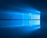 Das Windows 10 Logo leuchtet blau vor einem dunklen Hintergrund. Informiere dich über die Windows 10 Systemanforderungen.