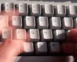 Hände tippen schnell auf einer Tastatur. Vielleicht wird gerade ein Befehl wie "diskpart delete partition" eingegeben.