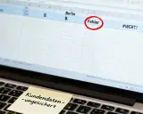 Laptop mit Excel-Tabelle, die einen Fehler markiert. Ein Haftnotiz warnt: "Kundendaten – ungesichert".