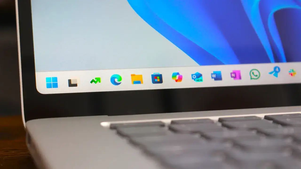 Taskleiste von Windows 11 mit Icons, darunter ein Pfeil nach oben und ein Kreis, der an Netspeedmonitor erinnert.